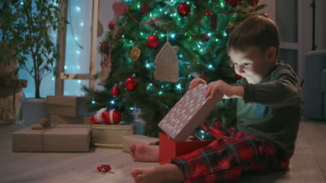 Adorable-three-year-old-boy-opening-his-Christmas-gift-and-finding-a-teddy-bear-inside.-High-quality-4k-footage